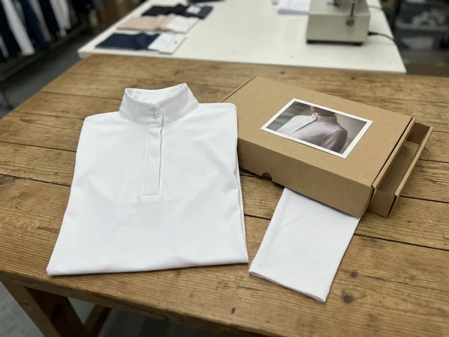 Camisa de muestra blanca junto a su caja