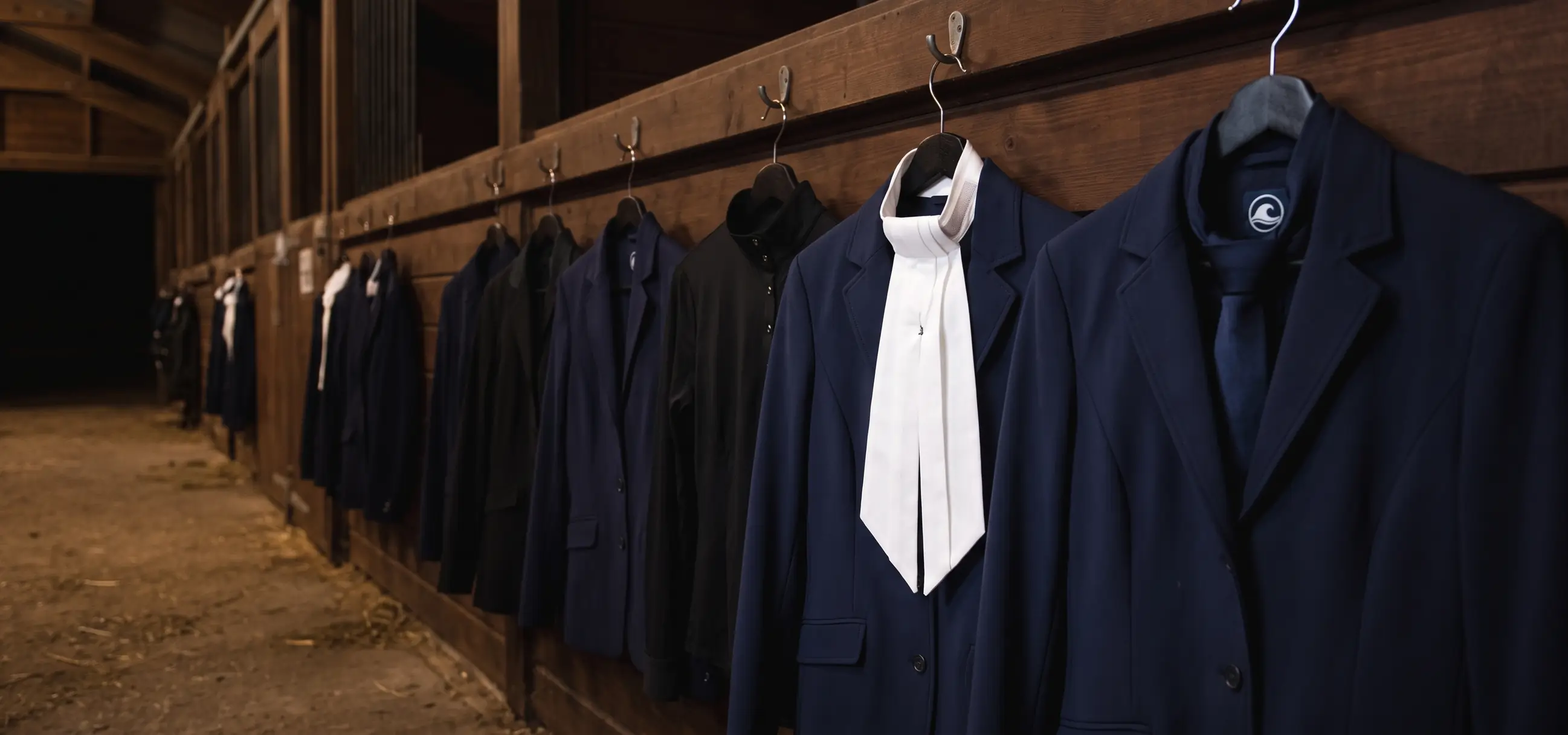 Pasillo de cuadras con chaquetas de concurso colgadas