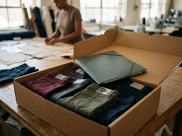 Caja del pedido con breeches doblados y el informe del lote