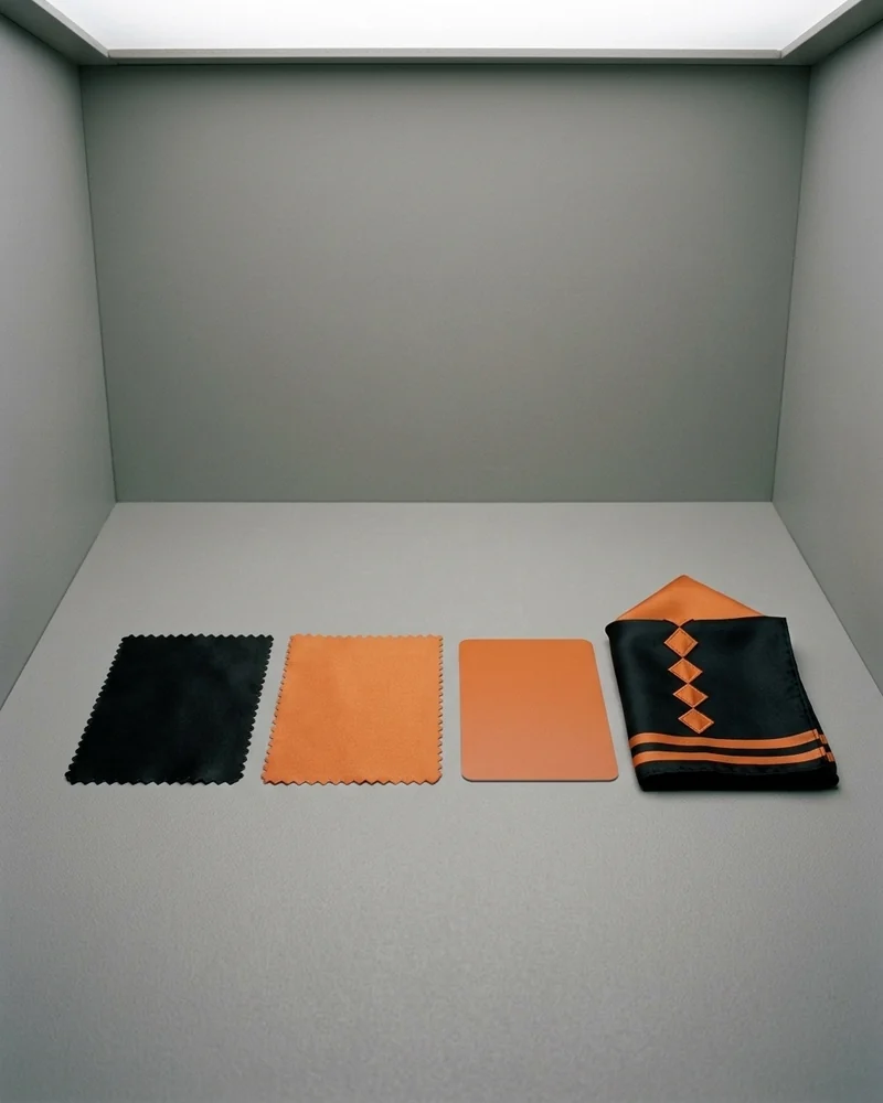 Lab dips de la cuadra negro y naranja junto a la referencia en la cabina de luz